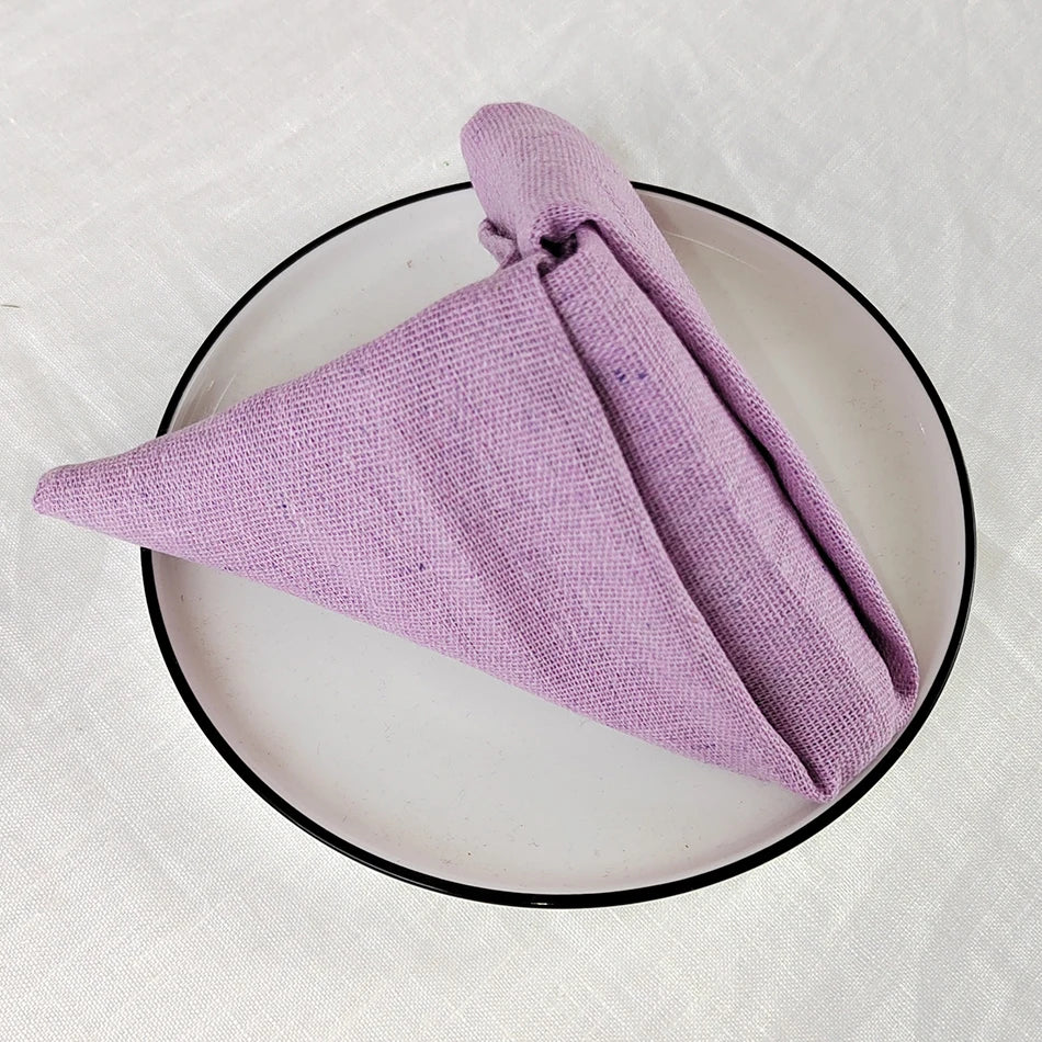 Serviette de bain violette enroulée dans un cadre noir circulaire.