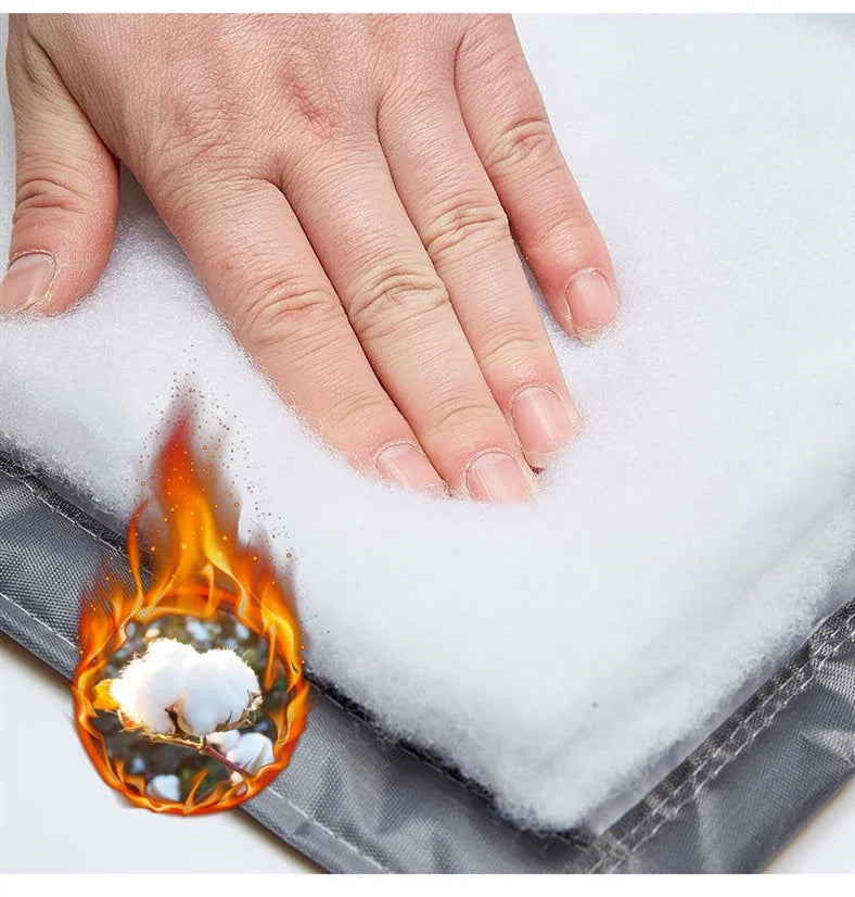 Main appuyée sur l’épaisse couche de coton isolant du rideau de porte, mettant en avant la protection thermique et ignifuge du matériau.