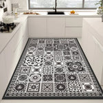 Tapis noir et blanc orné de motifs géométriques et floraux, créant un élément décoratif élégant et contemporain dans cette cuisine moderne.