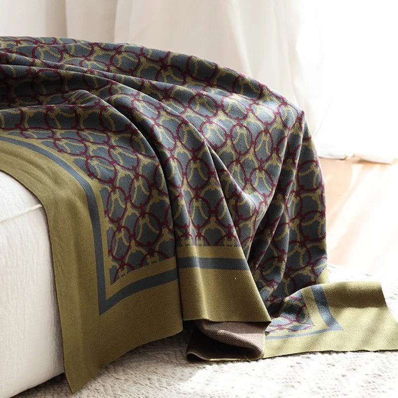 Plaid vert et gris motif géométrique posé sur lit