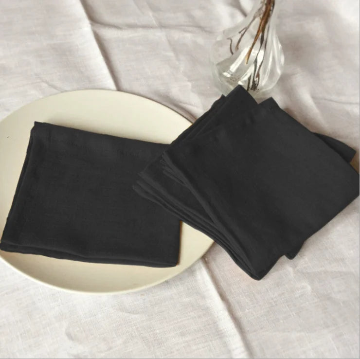 Jeu de serviettes de bain noires décontractées sur une surface blanche.