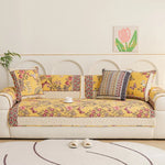 Un canapé confortable dans un style vintage avec des motifs floraux colorés et des coussins décoratifs, dans un salon lumineux et accueillant.