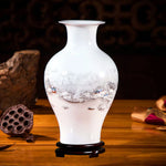 Un vase en porcelaine blanche avec des motifs de paysage enneigé délicatement peints.