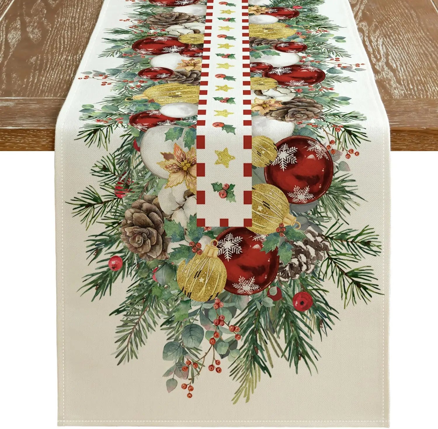 Décoration de table de Noël avec guirlande de pins, boules rouges et dorées, pommes de pin et autres ornements festifs.