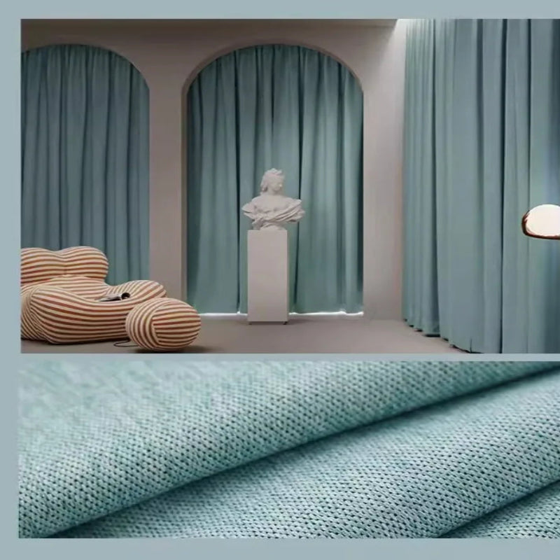 Des rideaux bleus, suspendus à une fenêtre, apportant une texture textile douce et naturelle à la décoration intérieure, semblable à un papier peint de luxe. Les rideaux en polyester, un matériau naturel, créent une atmosphère chaleureuse et accueillante dans la pièce.