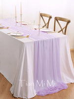 Une table de salle à manger élégante, parée de nappes blanches et de bougeoirs, avec des chaises en bois, pour une occasion spéciale.