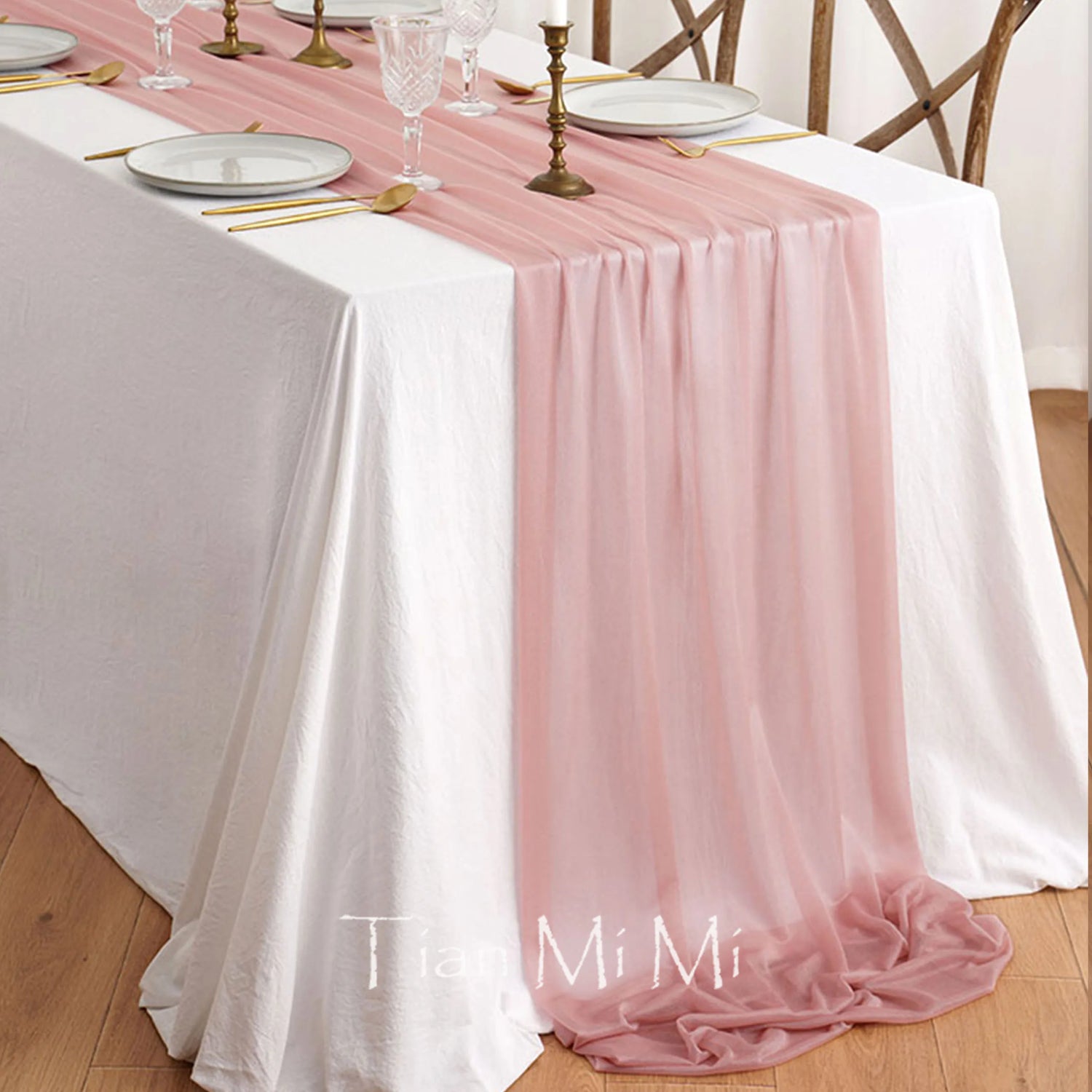 Cette élégante table de fête se démarque par ses tissus blancs et roses, ainsi que par ses accessoires dorés qui créent une ambiance raffinée et chaleureuse.