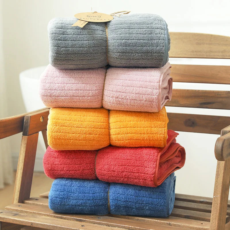 Une pile de serviettes moelleuses de différentes couleurs vives et douces, empilées sur un support en bois.