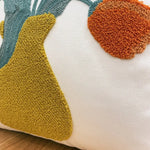 Coussin décoratif avec des motifs géométriques aux couleurs vives sur fond blanc.