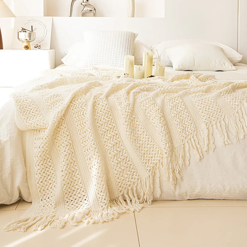 Couverture texturée blanche douillette et invitante sur un lit avec des oreillers immaculés, créant une ambiance chaleureuse et confortable dans la chambre.