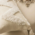 Gros plan sur la texture douce et moelleuse d'un tissu blanc recouvert de flocons de neige, évoquant une scène hivernale apaisante.