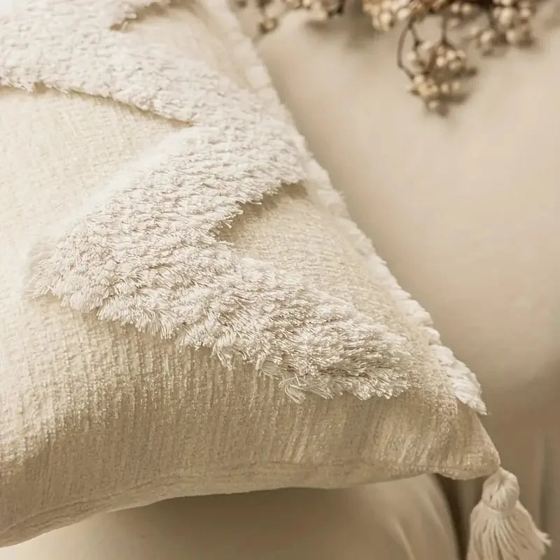 Gros plan sur la texture douce et moelleuse d'un tissu blanc recouvert de flocons de neige, évoquant une scène hivernale apaisante.