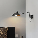 Lampe de lecture design blanche installée au-dessus d'un lit contemporain