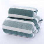 Serviette de bain rayée gris clair pliée dans une salle de bain moderne