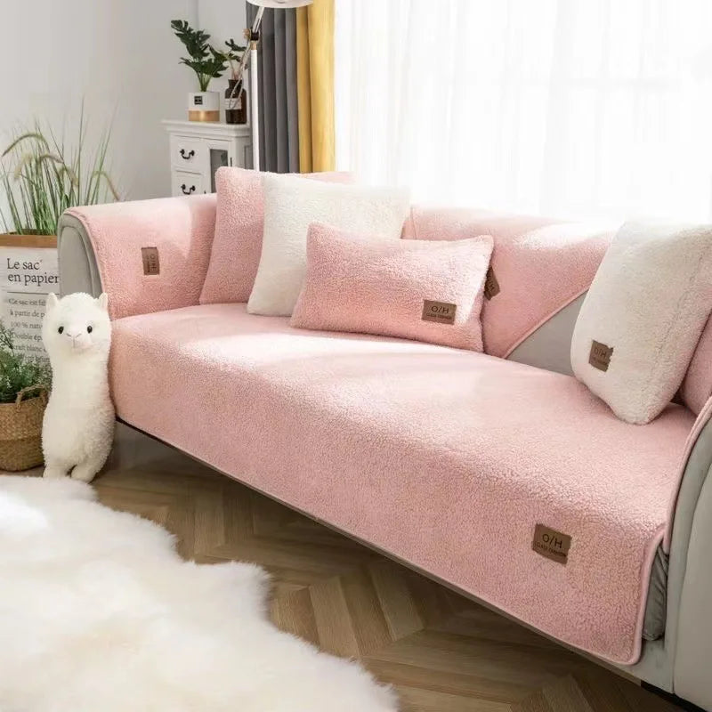 Un canapé confortable et douillet, avec des coussins roses et moelleux, dans un décor cosy et chaleureux, créant une ambiance accueillante et relaxante.