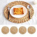 Set de table en paille naturelle et rotin rond couleur unie sur une table en bois