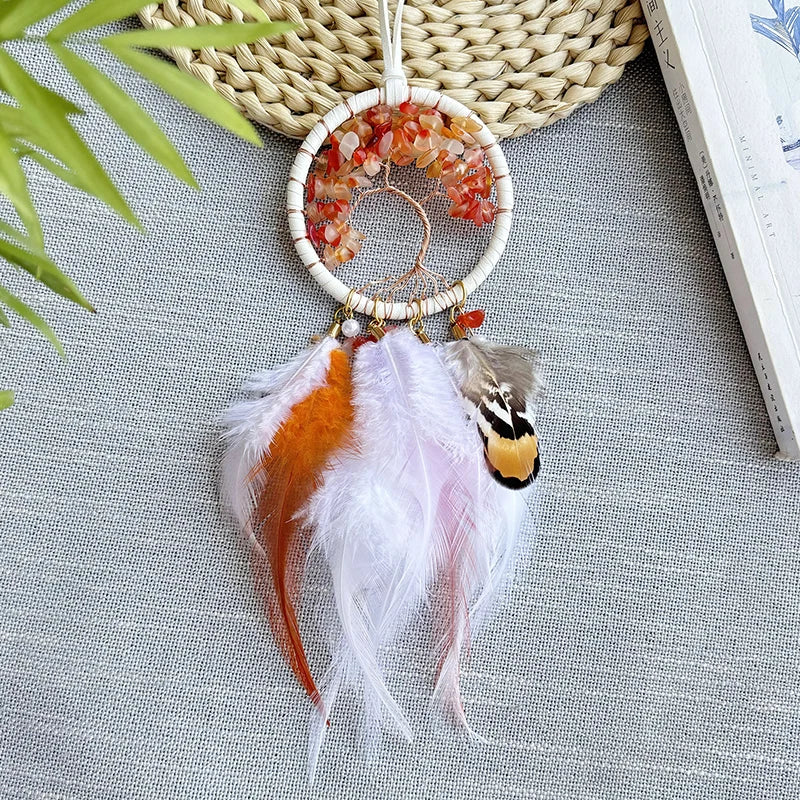 Capteur de rêves artisanal avec anneaux en perles et plumes colorées, suspendu sur un fond de motifs végétaux.