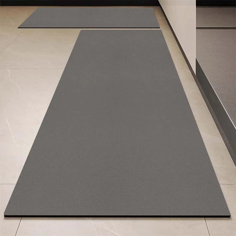 Le tapis gris épais et rectangulaire occupe une grande partie de la surface de la pièce, offrant un sol confortable et élégant.