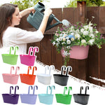 Jardinière suspendue rose avec plantes vertes