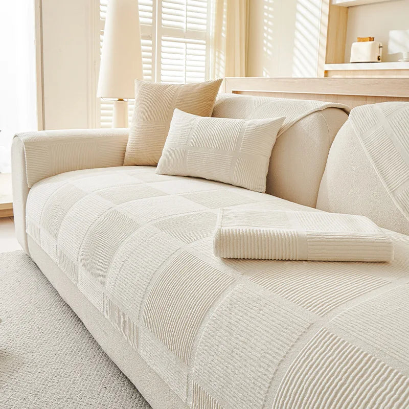 Un canapé moelleux et confortable avec des coussins beiges rayés, parfait pour se détendre dans un salon lumineux et apaisant.