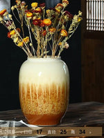 Un beau vase en céramique multicolore rempli de fleurs d'automne séchées, créant une atmosphère chaleureuse et automnale.