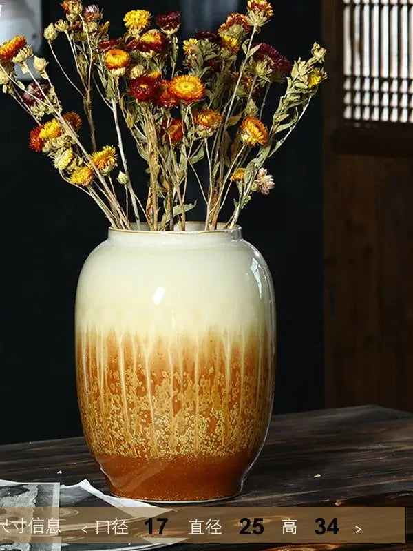 Un beau vase en céramique multicolore rempli de fleurs d'automne séchées, créant une atmosphère chaleureuse et automnale.