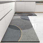 Tapis de cuisine moderne avec un motif géométrique abstrait de lignes et de formes en gris et en beige.