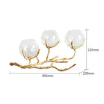 Détail des branches dorées sur vase en verre transparent
