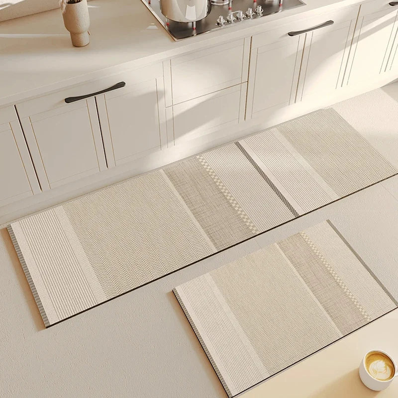 Motifs de tapis et de passants de porte en fibres naturelles sur un sol de cuisine blanc.