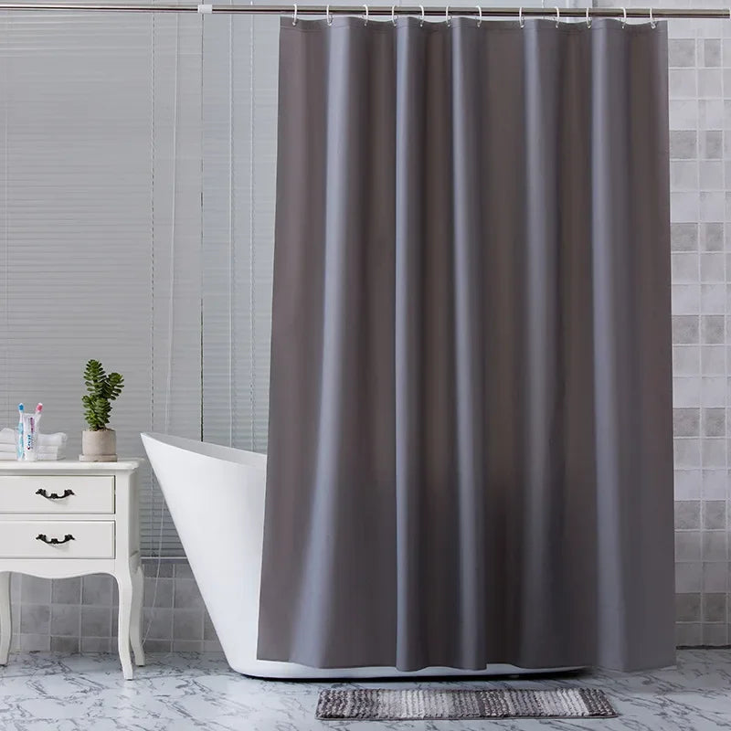 Rideau de douche gris en argent, suspendu au-dessus d'une baignoire dans une salle de bain équipée de robinets et d'accessoires de plomberie argentés, y compris un évier et d'autres installations de plomberie. Le rideau, principal élément de l'image, apporte une touche d'élégance et de fonctionnalité à l'ensemble de la salle de bain.