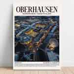 Photographie aérienne spectaculaire de la ville d'Oberhausen en Allemagne, avec ses structures architecturales, ses parcs d'attractions et ses rivières illuminés de nuit.