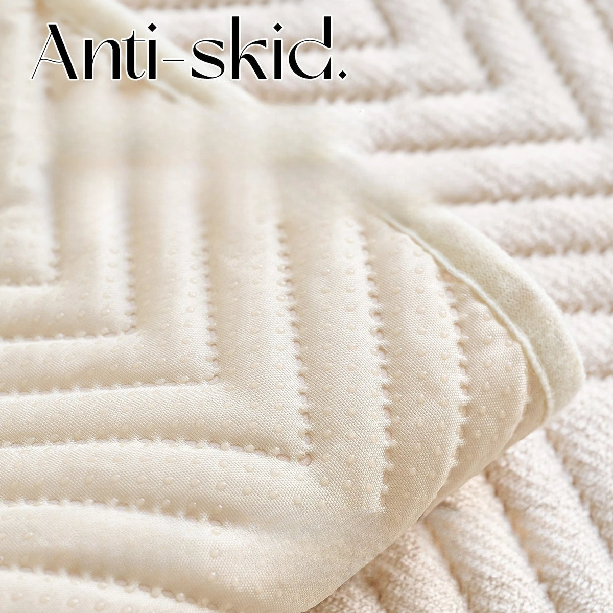 Gros plan sur une texture douce et moelleuse de tissu blanc rayé, avec le texte "Anti-skid" imprimé en surbrillance.