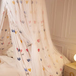 Rideau blanc léger avec des motifs de cœurs colorés, créant une ambiance douce et romantique.