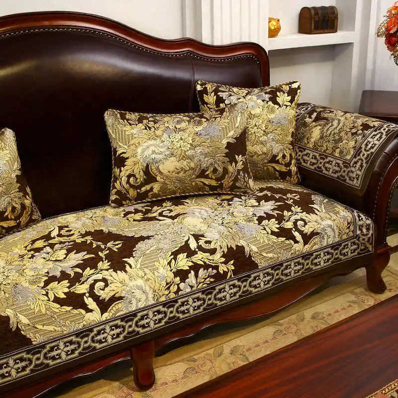 Un canapé vintage en bois foncé avec des coussins ornés de motifs floraux dorés et foncés, créant une ambiance chaleureuse et élégante dans cette pièce.
