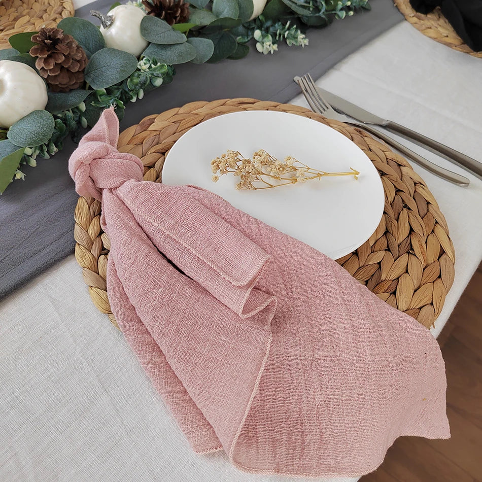 Une belle nappe de table tressée ornée de décorations naturelles, avec un linge de table rose plié avec soin.