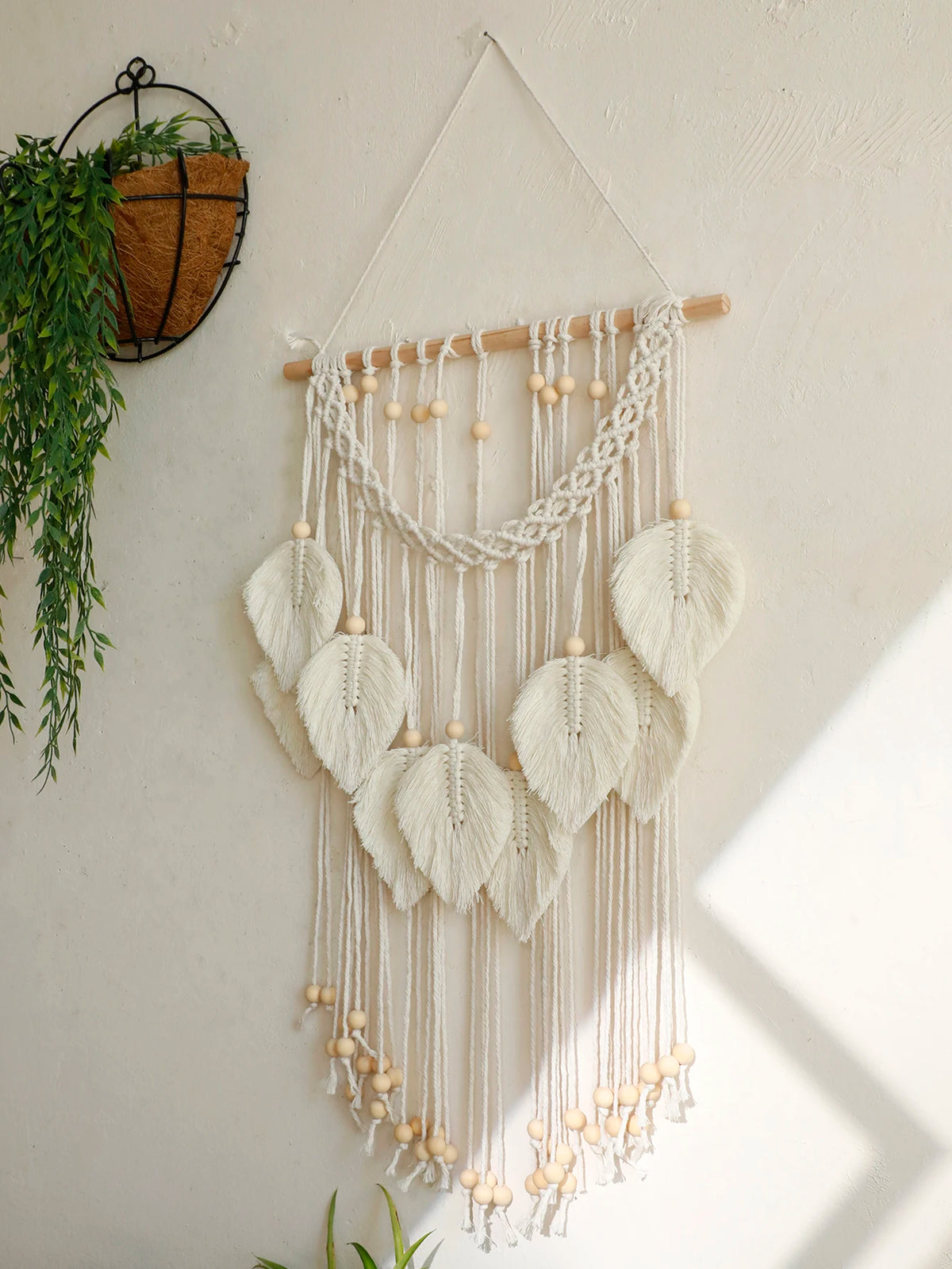 Détail tenture murale macramé tissée à la main avec perles en bois naturelles