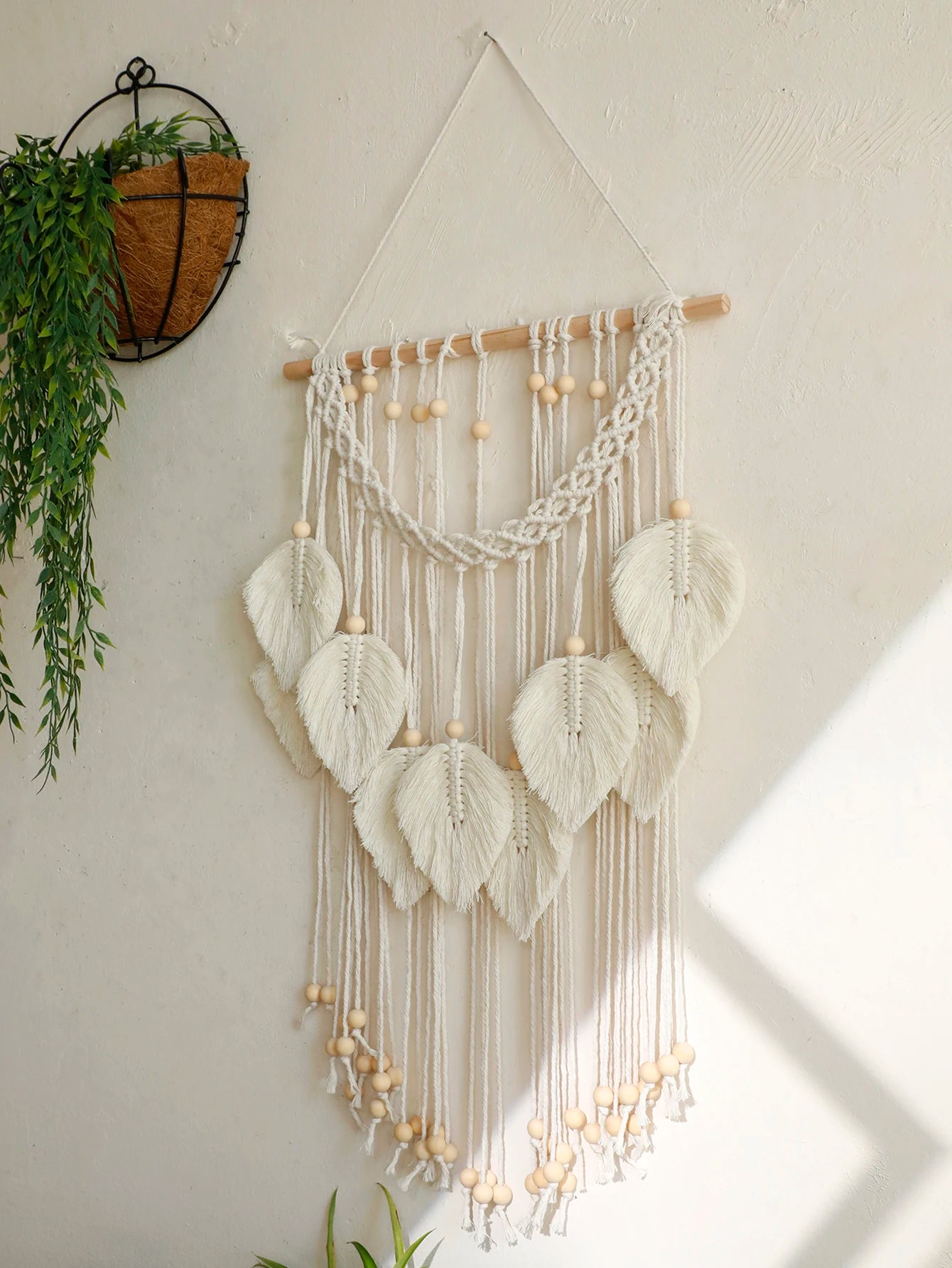 Détail tenture murale macramé tissée à la main avec perles en bois naturelles