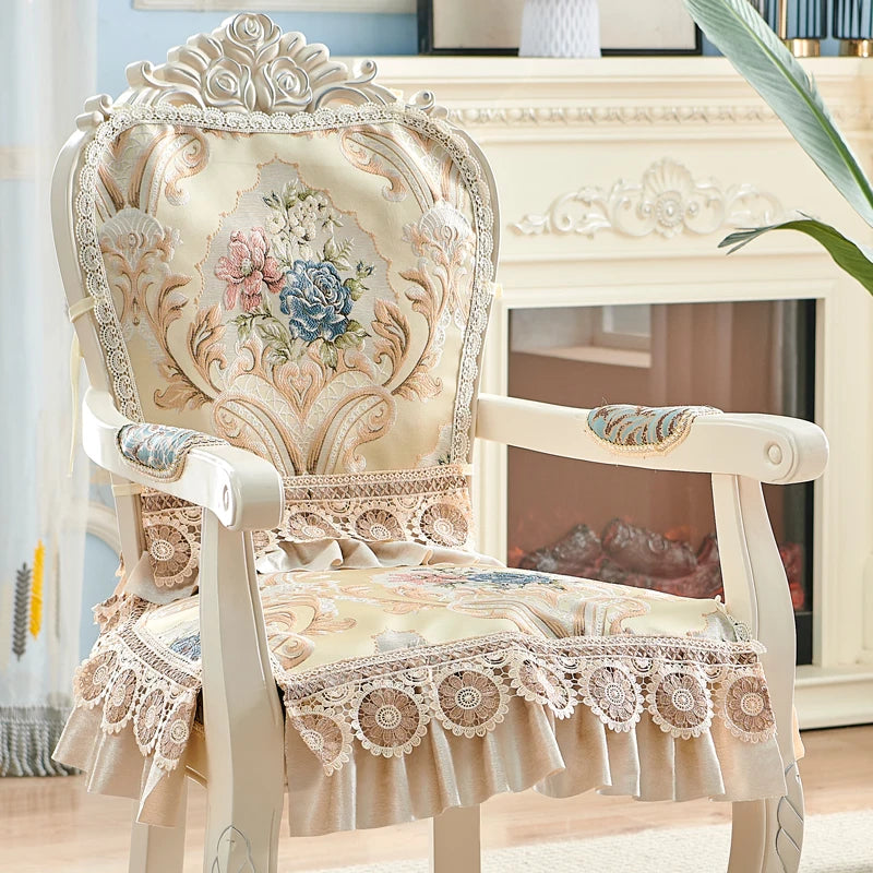Un fauteuil vintage orné de délicates broderies florales sur un fond beige créant une atmosphère chaleureuse et élégante.