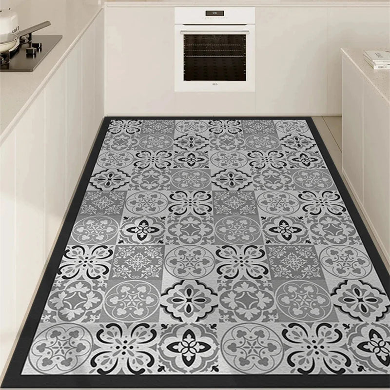 Tapis de sol motif carrelage en noir et blanc élégant et moderne, avec un design ornemental floral dans une cuisine lumineuse et épurée.