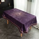 Nappe pourpre ornée d'un motif solaire doré et de symboles astrologiques, sur une table dans une pièce moderne.