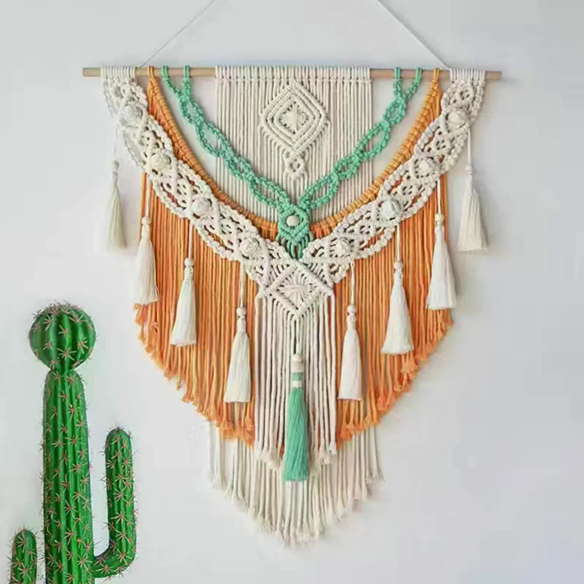 Tenture macramé accrochée au mur avec décoration naturelle autour