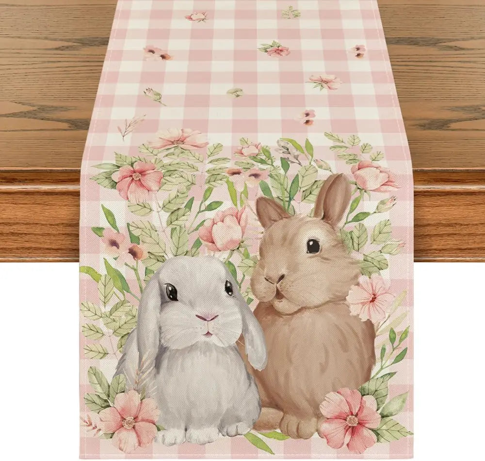 Deux lapins mignons entourés de fleurs roses délicates sur un fond à carreaux roses et blancs.