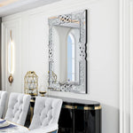 Miroir décoratif brillant avec un motif tressé unique, placé au-dessus d'un console noire et dorée, dans une pièce blanche et lumineuse.