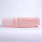 Serviette de bain en coton rose pâle, douce et absorbante.