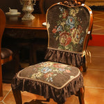 Chaise ancienne recouverte d'un beau tissu fleuri aux tons chauds, posée sur un sol en carrelage dans un intérieur confortable et élégant.