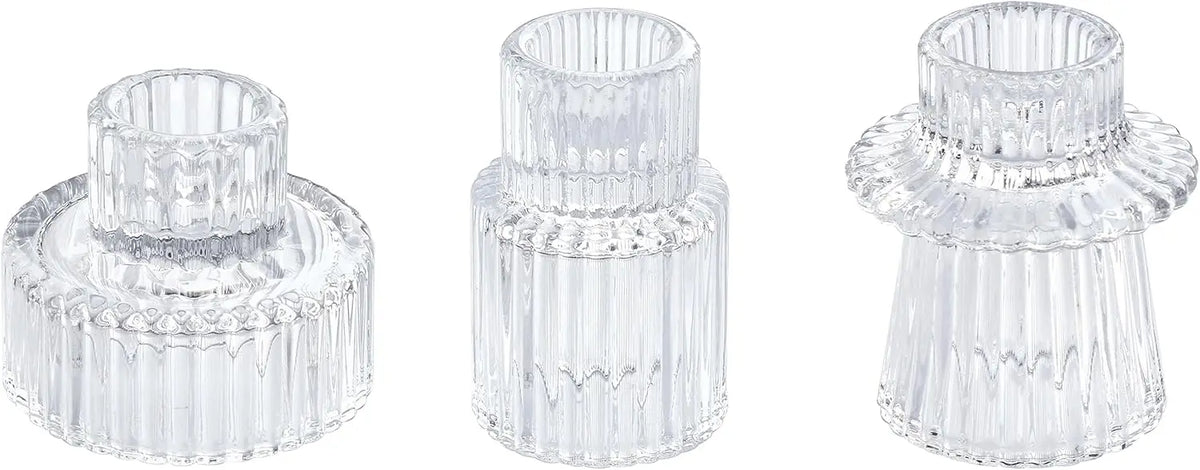 Trois photophores en cristal transparent aux formes distinctives, disposés sur un fond blanc, constituant un ensemble décoratif élégant et raffiné.