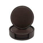Un ensemble de sous-verres circulaires en cuir de couleur sombre, avec une couture contrastée, posés dans un support en cuir assorti.