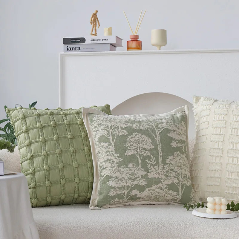 Un joli décor de chambre avec des coussins verts et des décorations sur une étagère, créant une ambiance apaisante et naturelle.