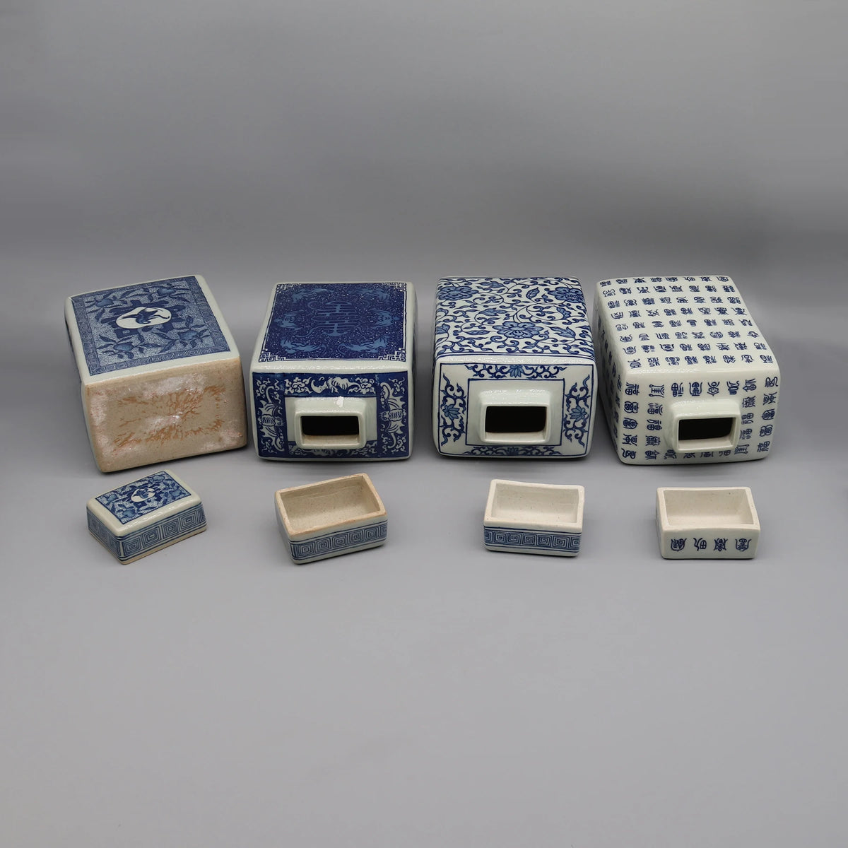 Une collection de boîtes décoratives en céramique bleu et blanc avec des motifs et des inscriptions orientaux.