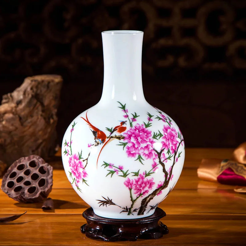Vase en porcelaine blanche orné de fleurs de pivoine roses et d'oiseaux colorés, posé sur un support en bois sculpté.